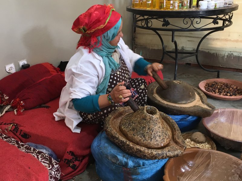 Moroccan woman grinding argan seeds