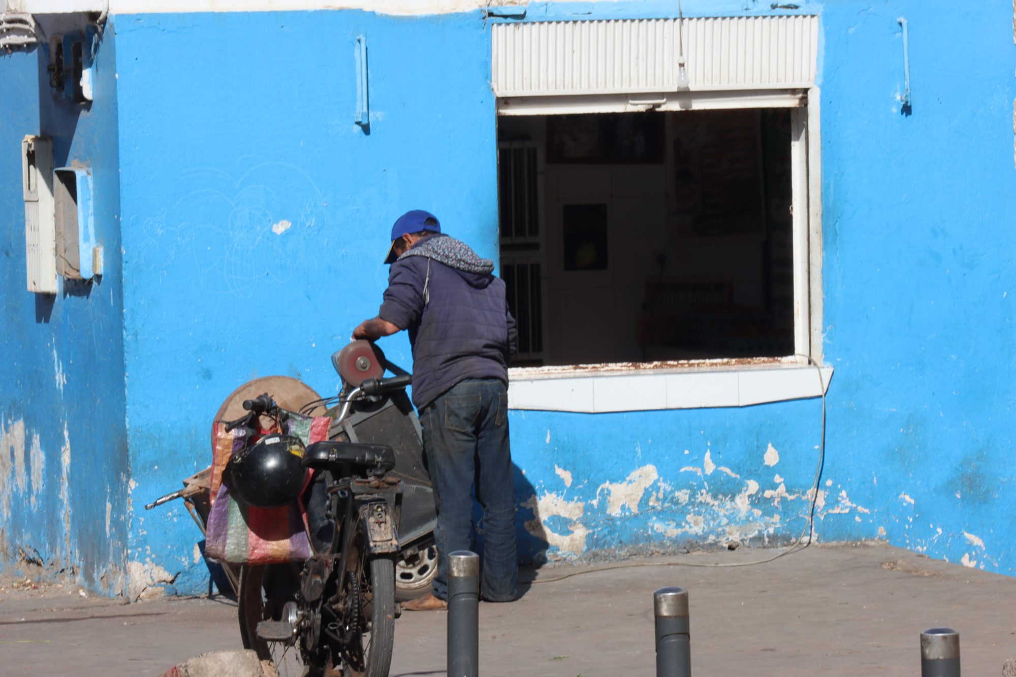 A blue house, man and motor bike