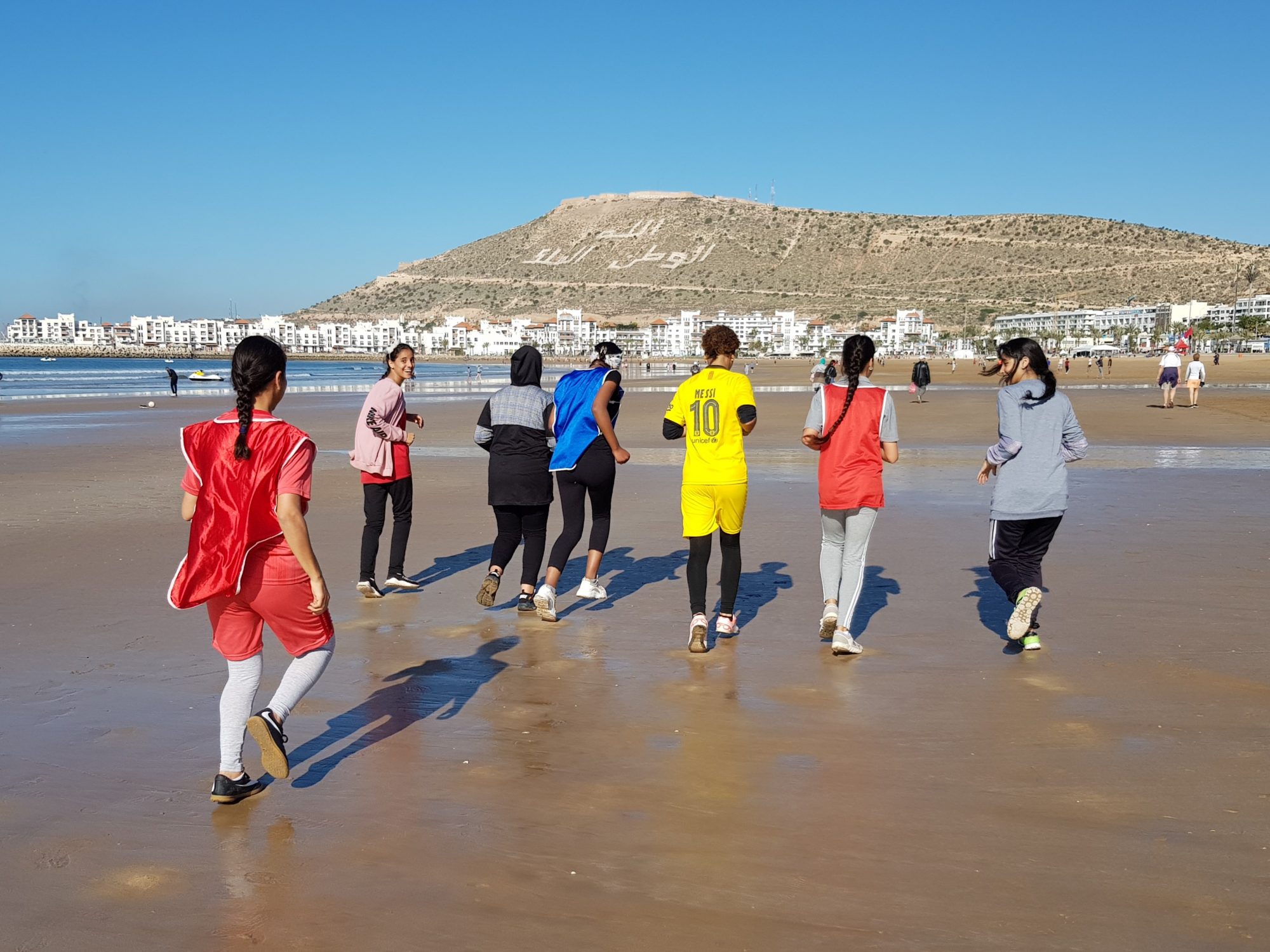 Moroccan girls jogging on Agadir beach